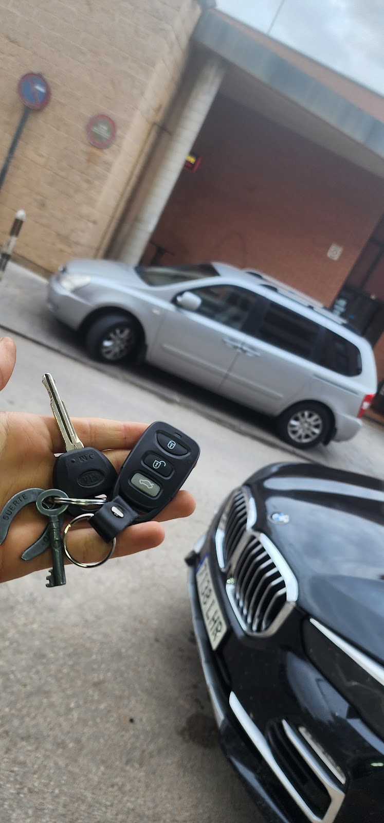 Llave Kia y mando programado, con BMW de fondo